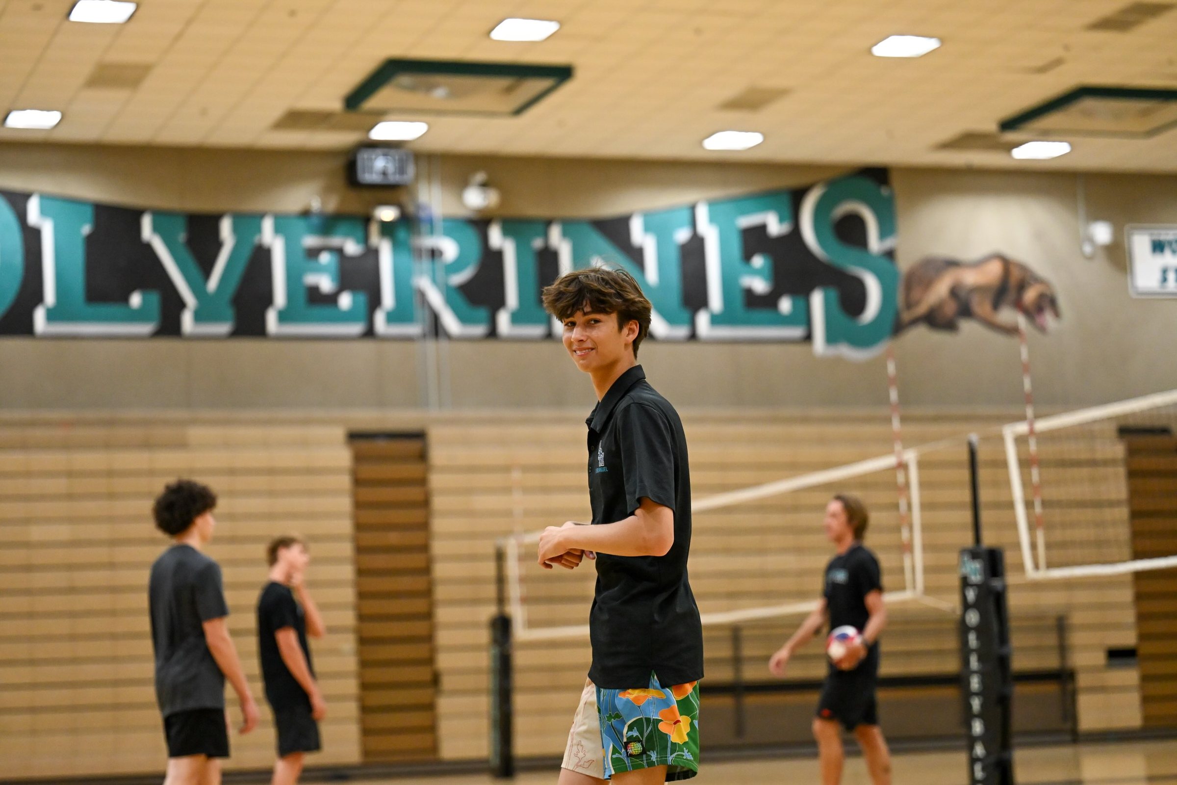 Players on the court beneath the Wolverines sign